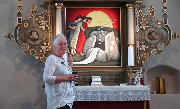 Alice Ravnholt viser alterbilledet, som hun malede til Ølstrup kirke